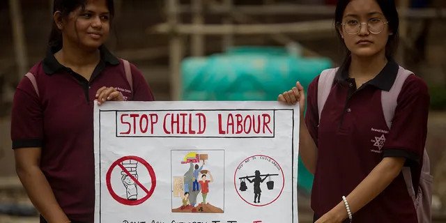 Students hold a poster to mark the World Day Against Child Labor in Kathmandu, Nepal, June 12, 2022